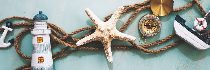 Maritim dekoration med fyr, sj&ouml;stj&auml;rna och fiskeb&aring;t