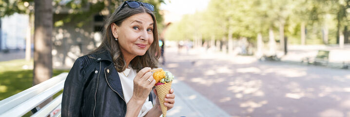 Kvinna med solglas&ouml;gon, glass och svart l&auml;tt skinnjacka
