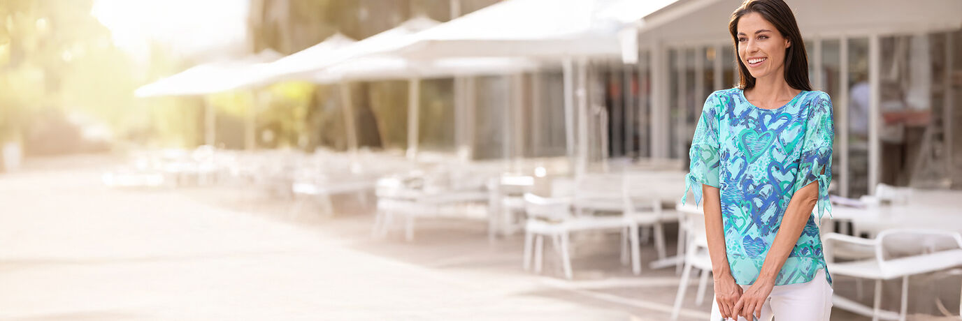 Dam i bl&aring; tunikatopp och vita byxor