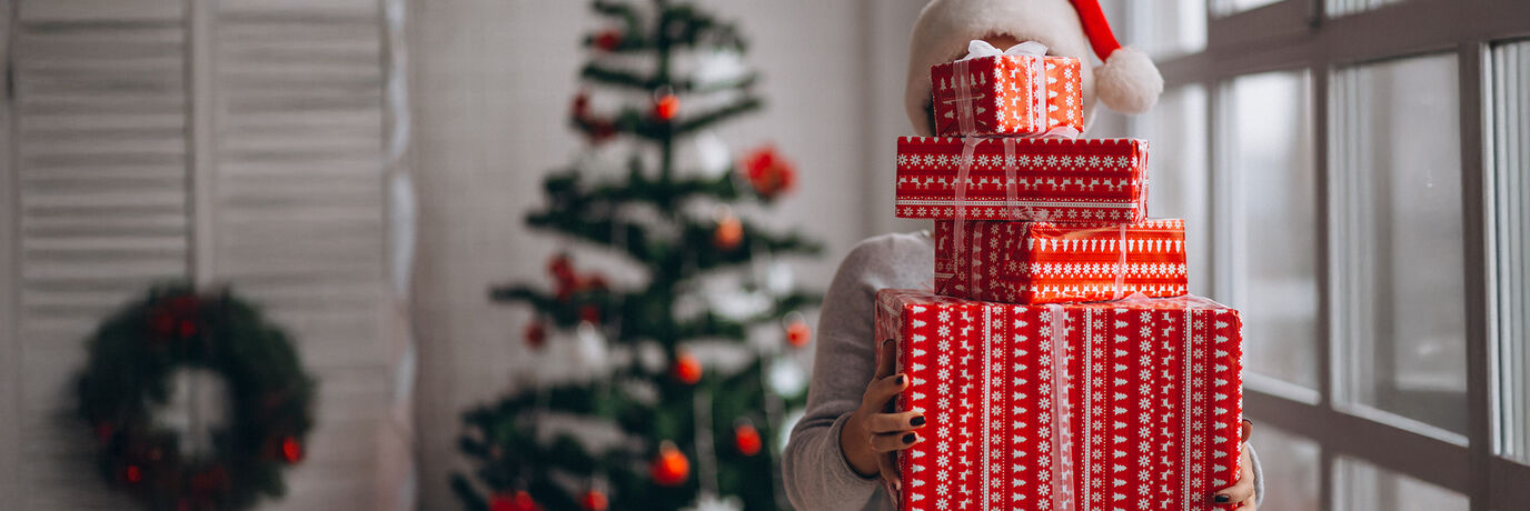 Kvinna med 4 presenter och julgran