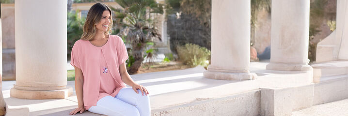 Dam i rosa blus och vita byxor