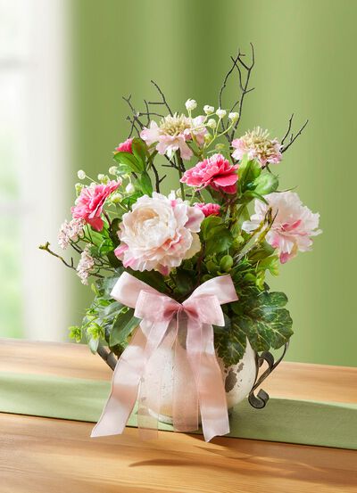 Blomsterarrangemang i kruka med handtag 