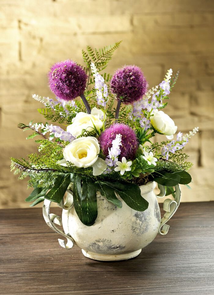 Arrangemang i en lerkruka med metallhandtag 