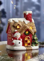 Upplyst hus med sn&ouml;gubbe 