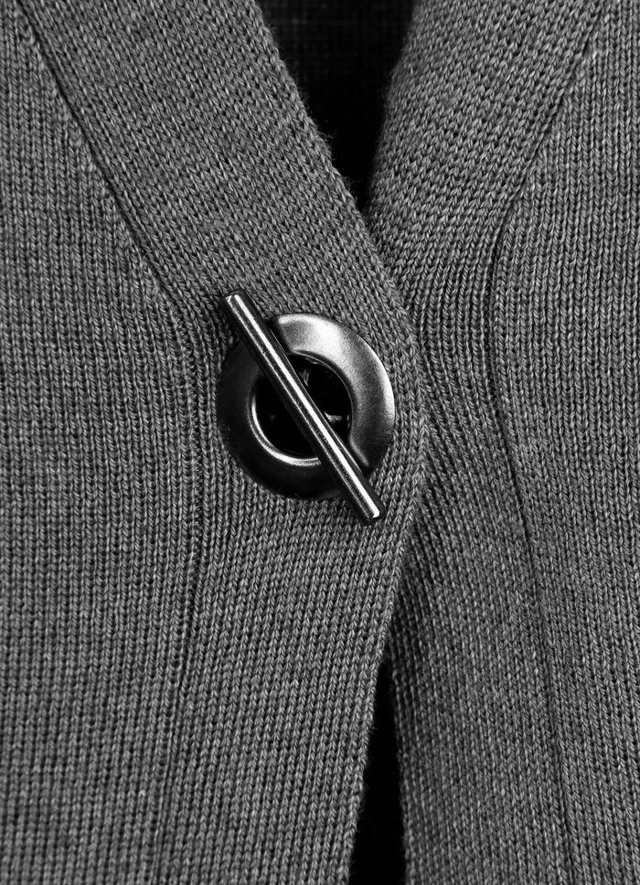 Stickad v&auml;st med dekorativ kn&auml;ppning GR&Aring;SPR&Auml;CKLIG