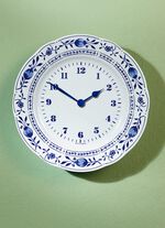 Keramisk v&auml;ggklocka med klassiskt l&ouml;km&ouml;nster 