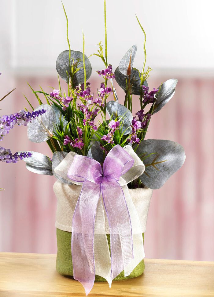 V&aring;rarrangemang med blommor och gr&auml;s i filtp&aring;se 