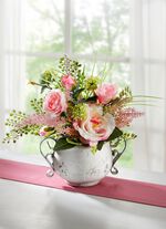 Arrangemang i kruka av konst och textilmaterial 