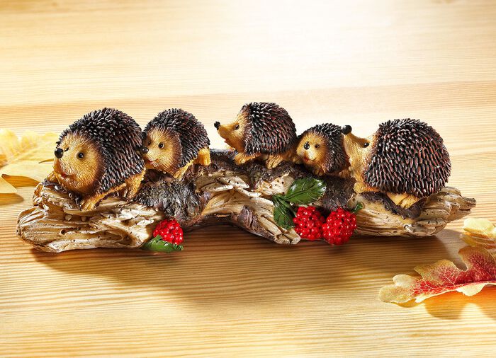 Igelkottsfamilj p&aring; en tr&auml;stam, gjord av stenharts 