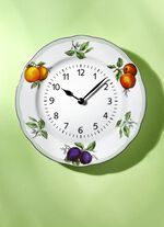 Keramisk v&auml;ggklocka med fruktdekoration 