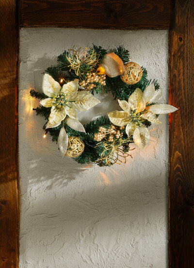 Upplyst grankrans med julstjärnablommor 