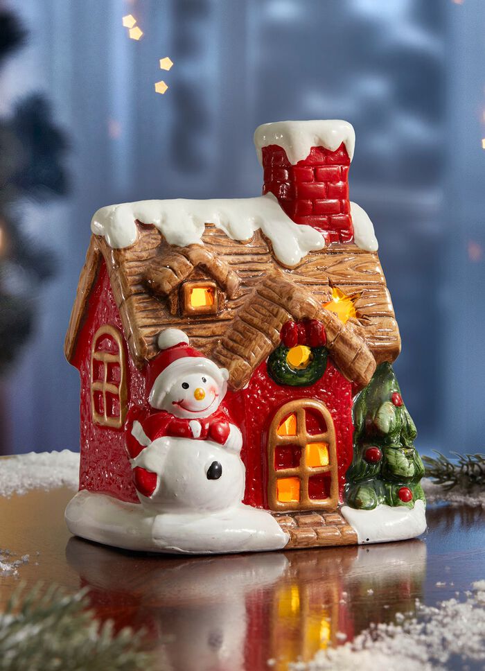 Upplyst hus med sn&ouml;gubbe 