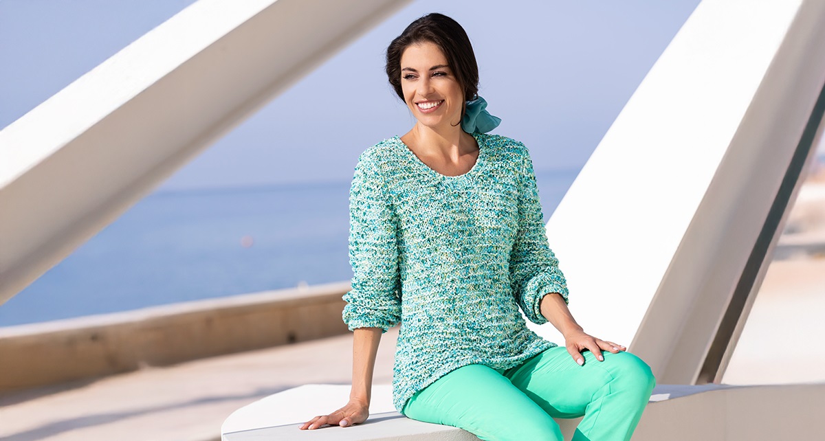 Kvinna i mintgrön tröja och jeans